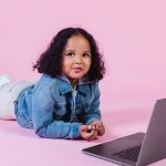 little ethnic girl using laptop in studio